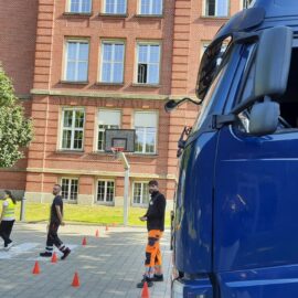 Eine Grundschülerin am Steuer eines stehenden LKWs in einer Übung zum Toten Winkel