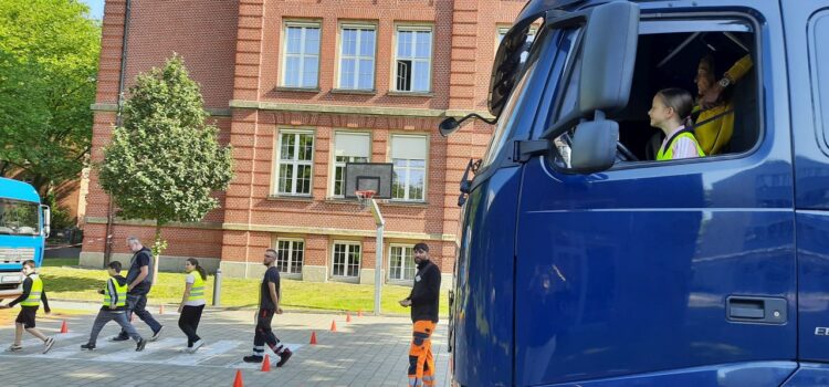 Eine Grundschülerin am Steuer eines stehenden LKWs in einer Übung zum Toten Winkel