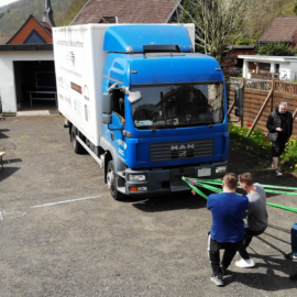 Schüler ziehen mit Leinen einen LKW vorwärts als Wettbewerb.